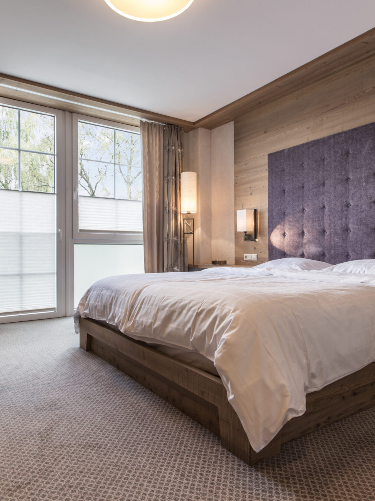 Modern hotel room with double bed and desk