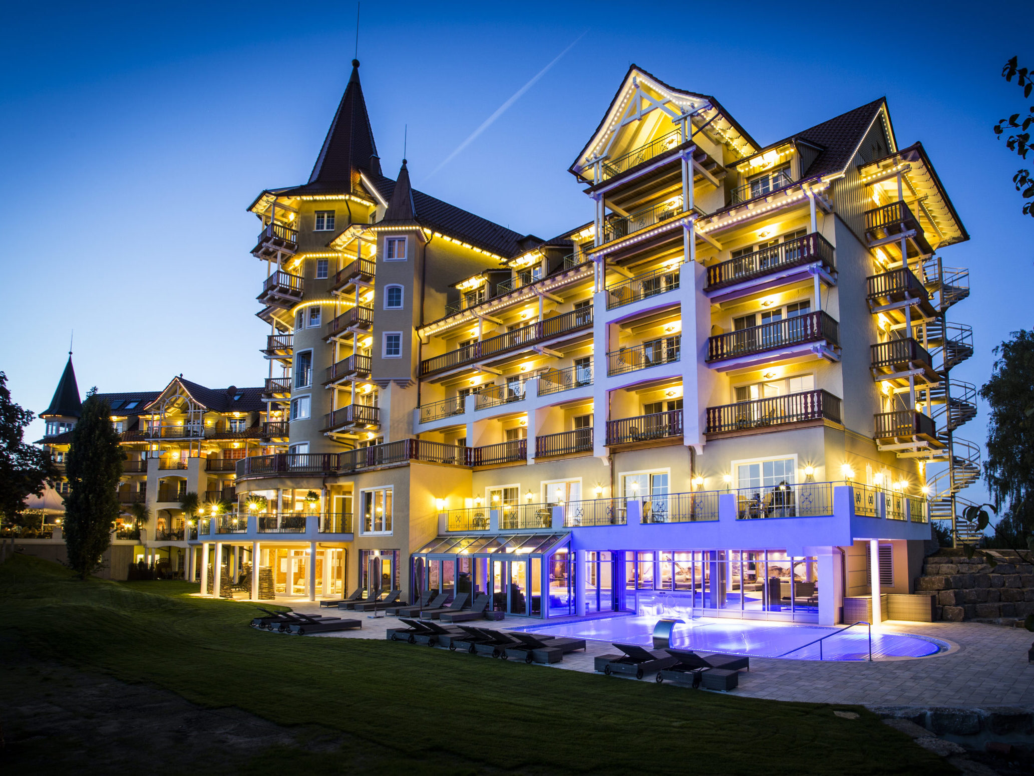 Exterior view of the Meiser SPA Resort near Dinkelsühl at night with lighting and pool area