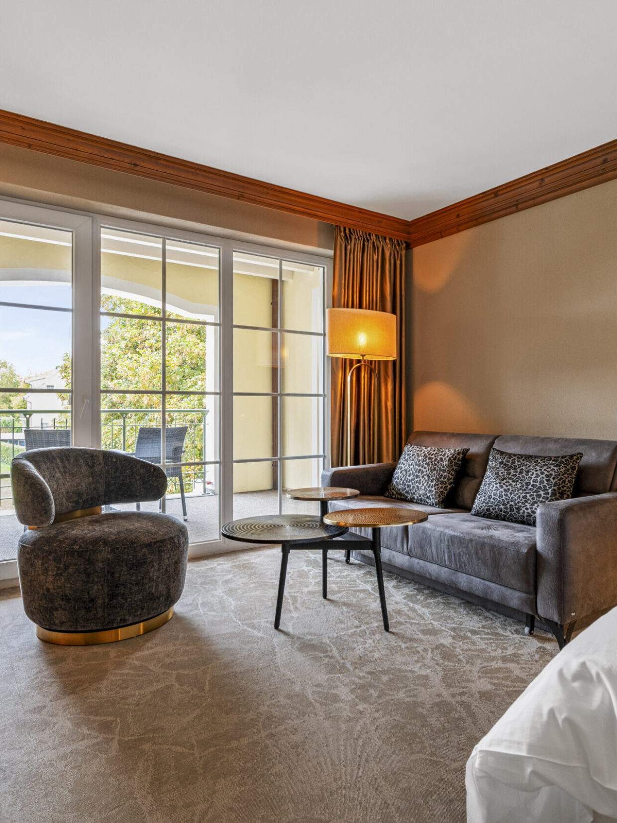 Luxurious hotel room with balcony and modern furnishings.