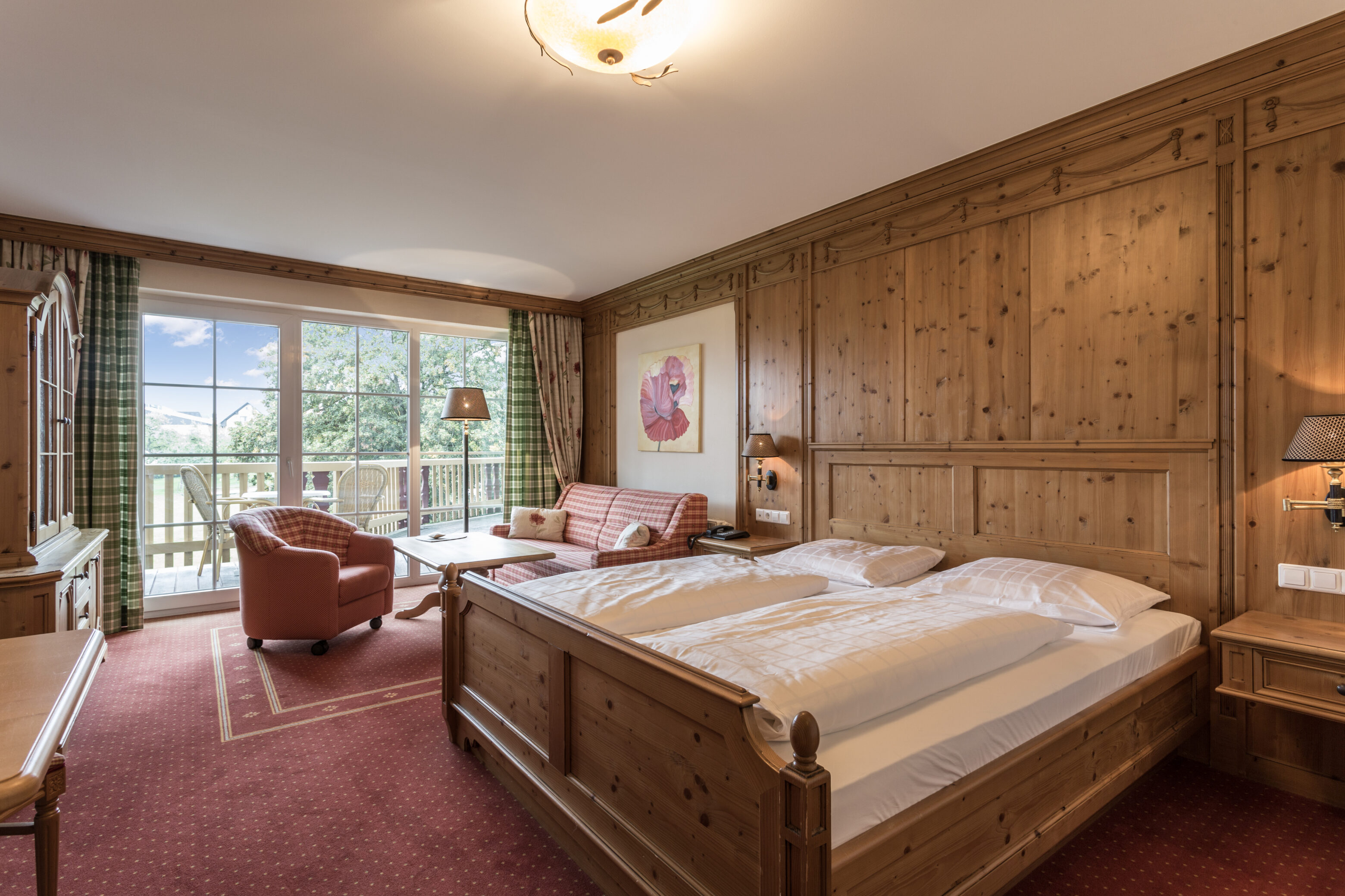 Gemütliches Hotelzimmer mit Holzinterieur und Balkonblick.
