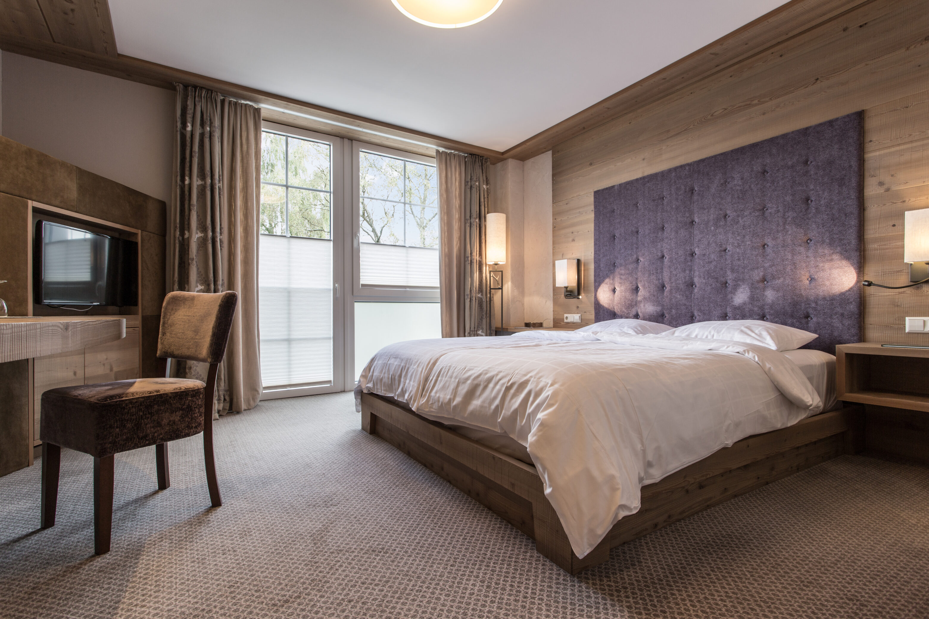 Modern bedroom with double bed and TV.