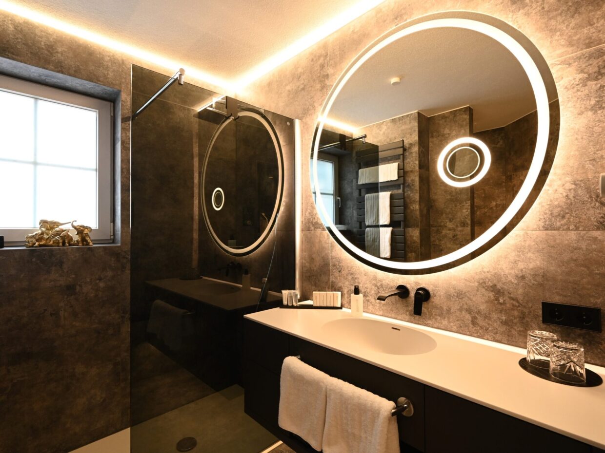 Modernes Badezimmer mit stimmungsvoller Beleuchtung und hochwertiger Ausstattung.