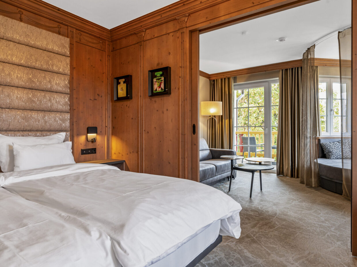 Gemütliches Hotelzimmer mit Wohnzimmer und Balkonansicht.