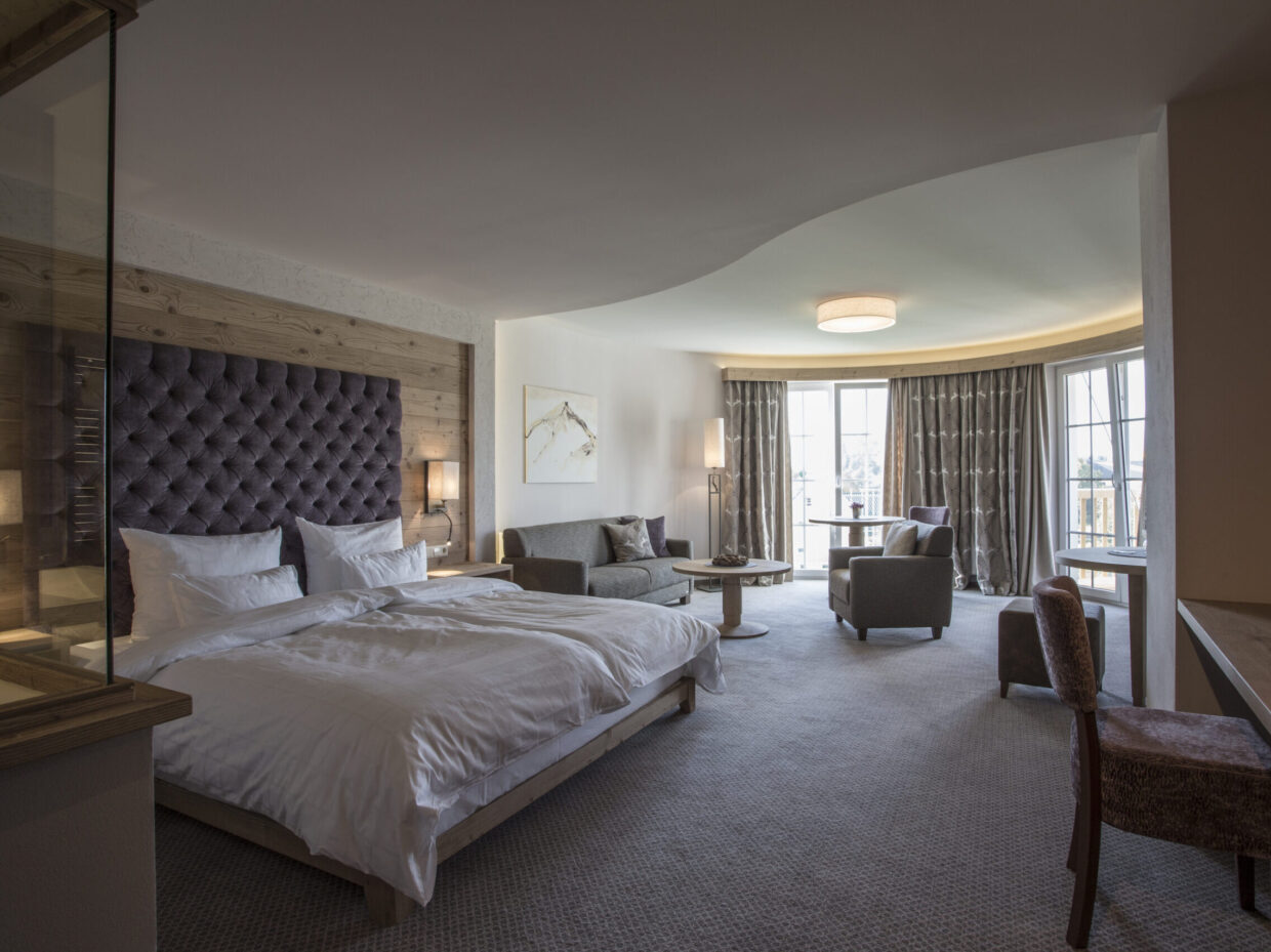 Spacious sleeping area with soft bed and cozy seating area.
