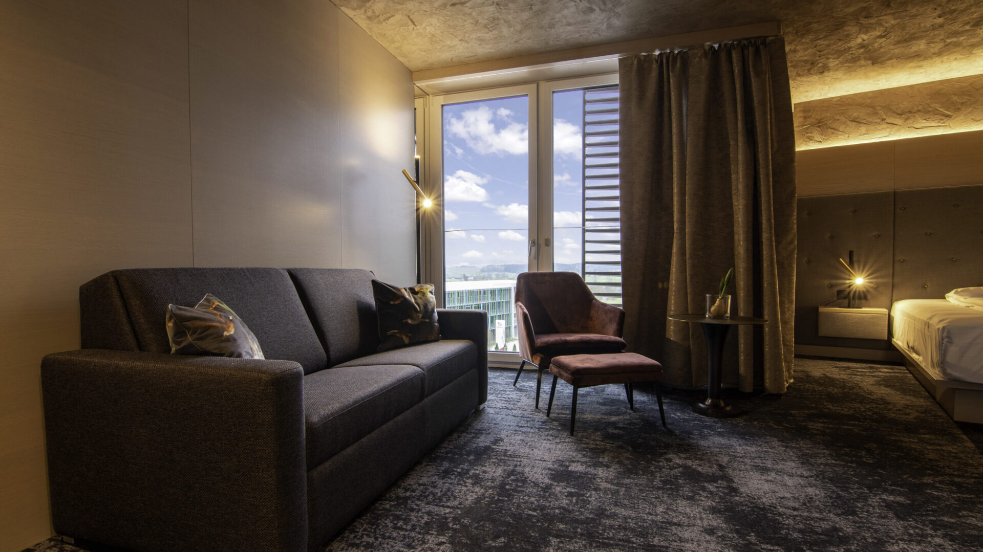 Modernes Hotelzimmer mit Sofa und Ausblick