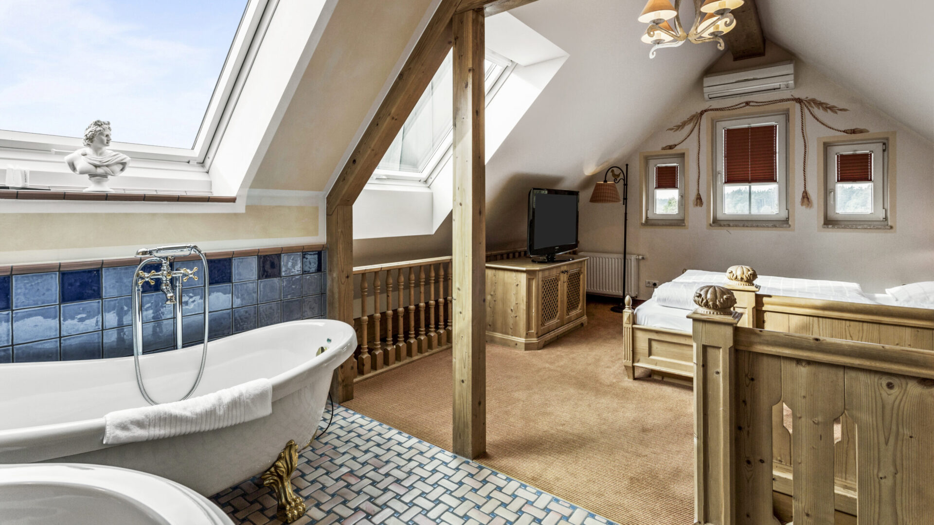 Gemütliches Dachgeschosszimmer mit Badewanne und Holzdekor