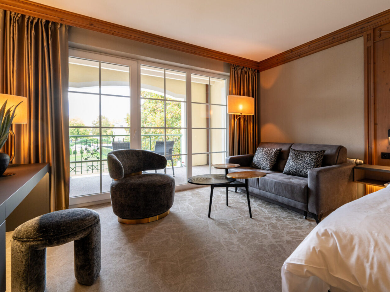 Modern superior room with balcony and cozy sitting area in the Meiser SPA Resort.