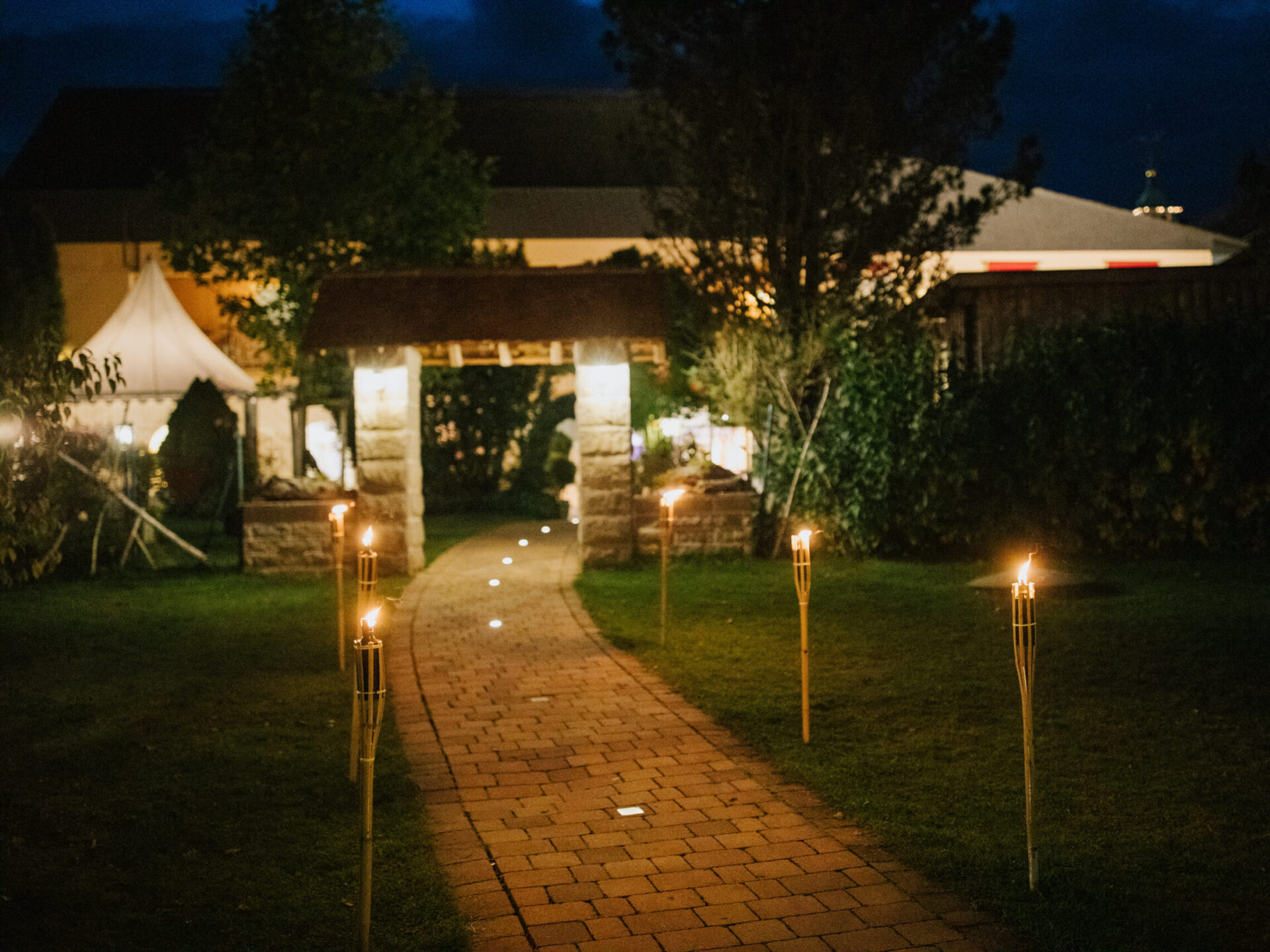 Illuminated garden path at night with torches