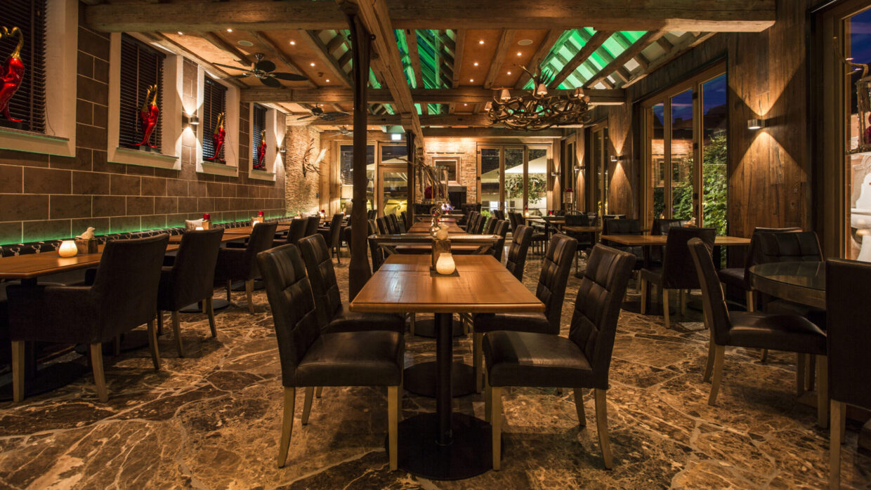 Gemütliches Restaurant mit holzverkleideter Einrichtung und Beleuchtung.