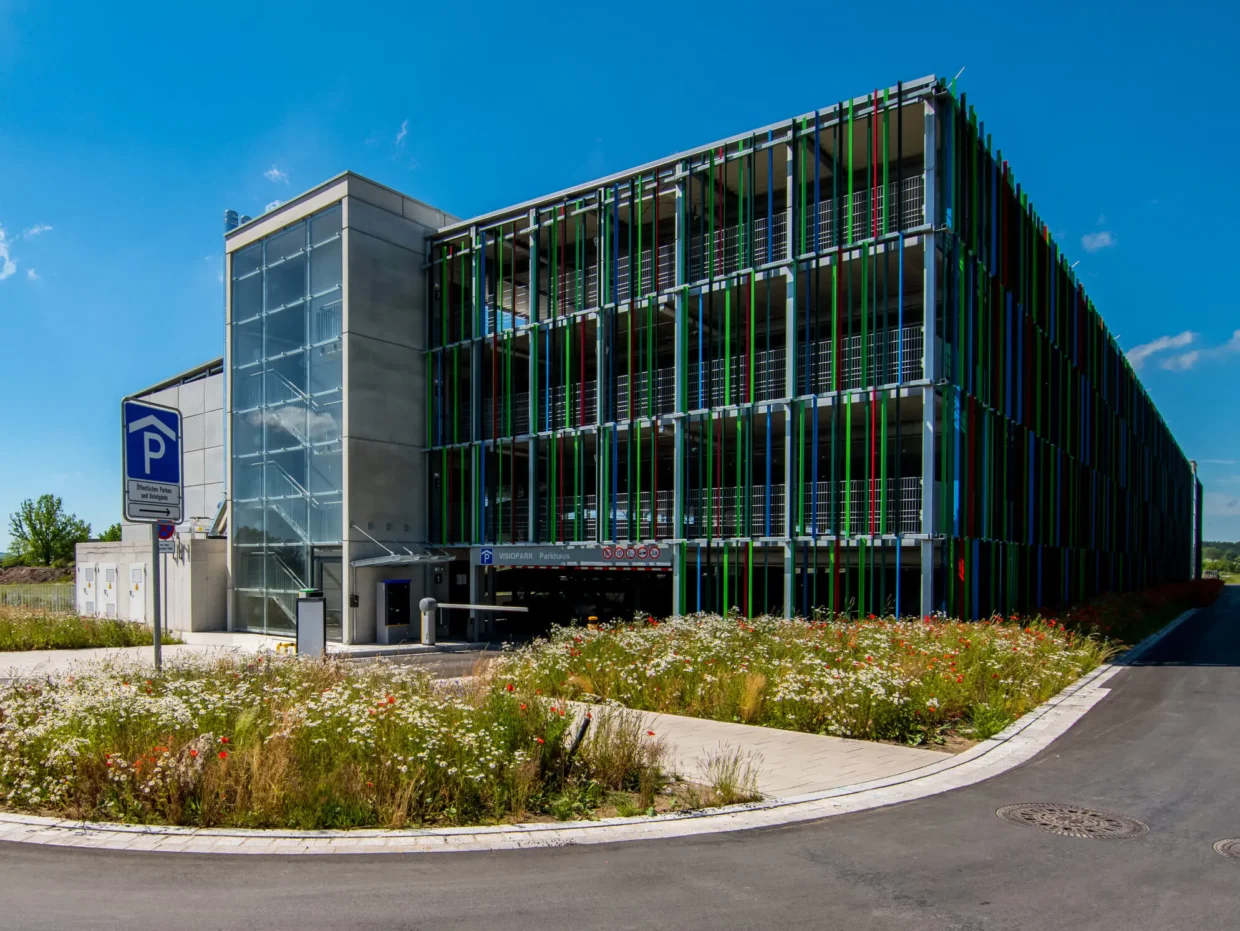 Mehrstöckiges Parkhaus mit buntem Glasaußenbereich.