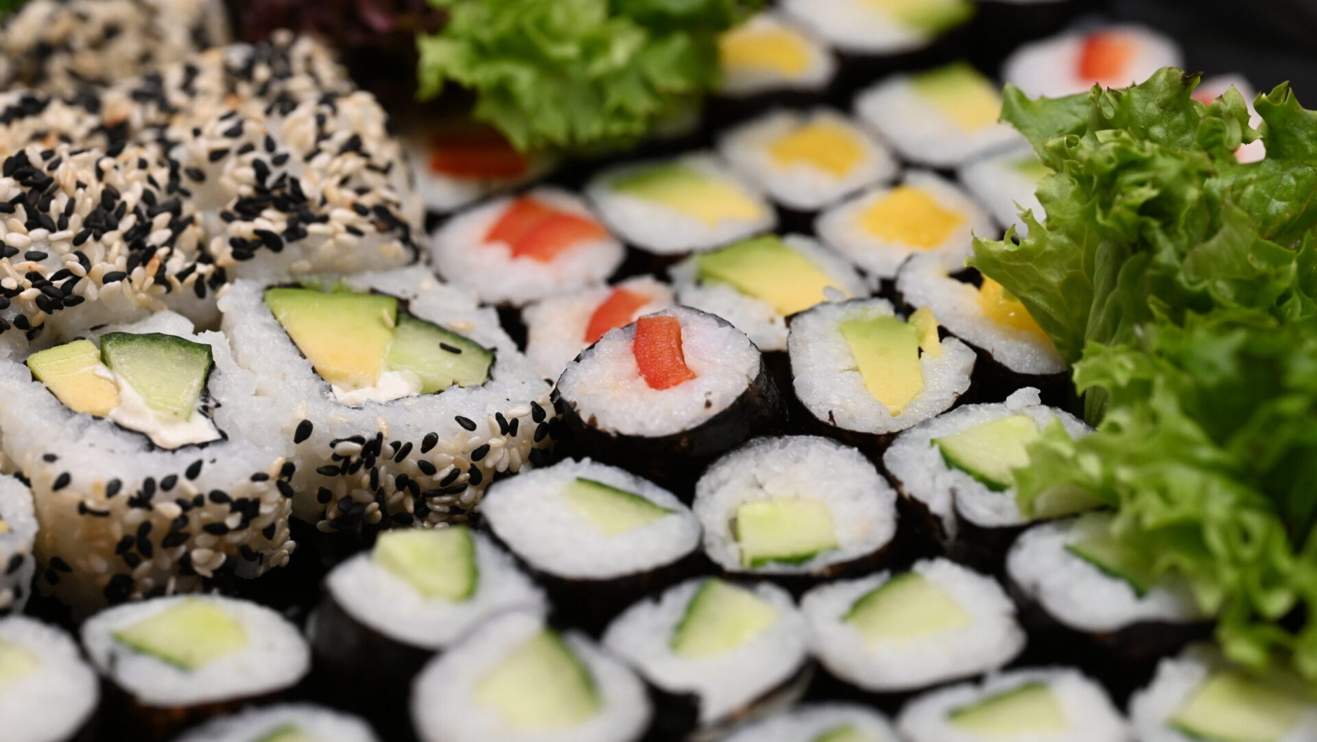 Verschiedene Sushirollen mit Gemüsefüllung und Sesam.