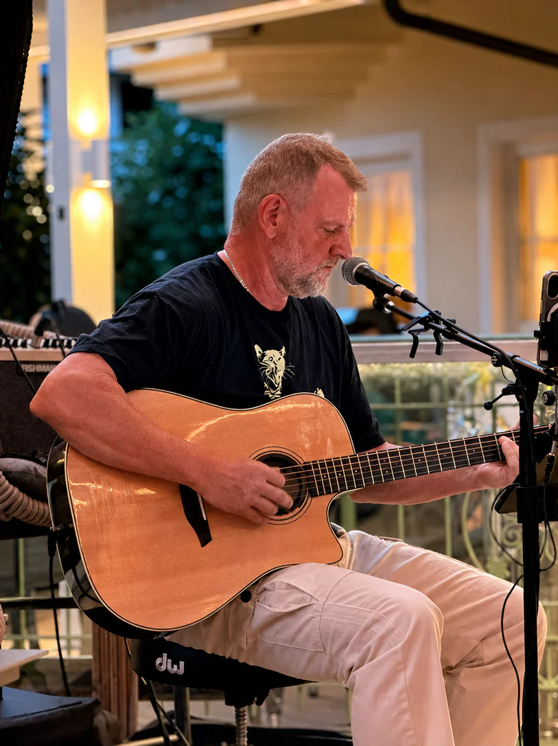 Mann spielt Akustikgitarre in Café