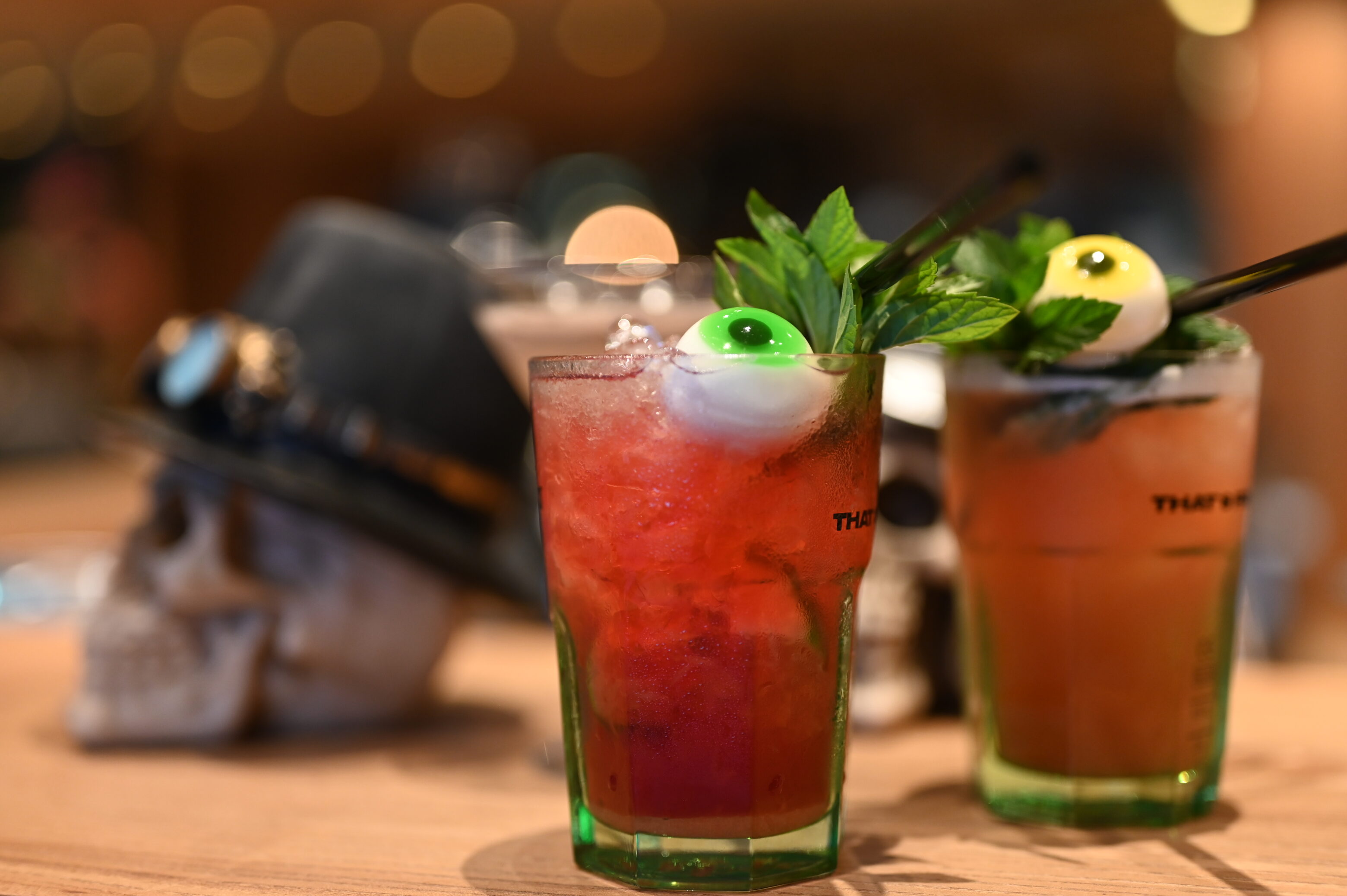 Halloween-Cocktails mit Deko-Schädel und Augenmotiv