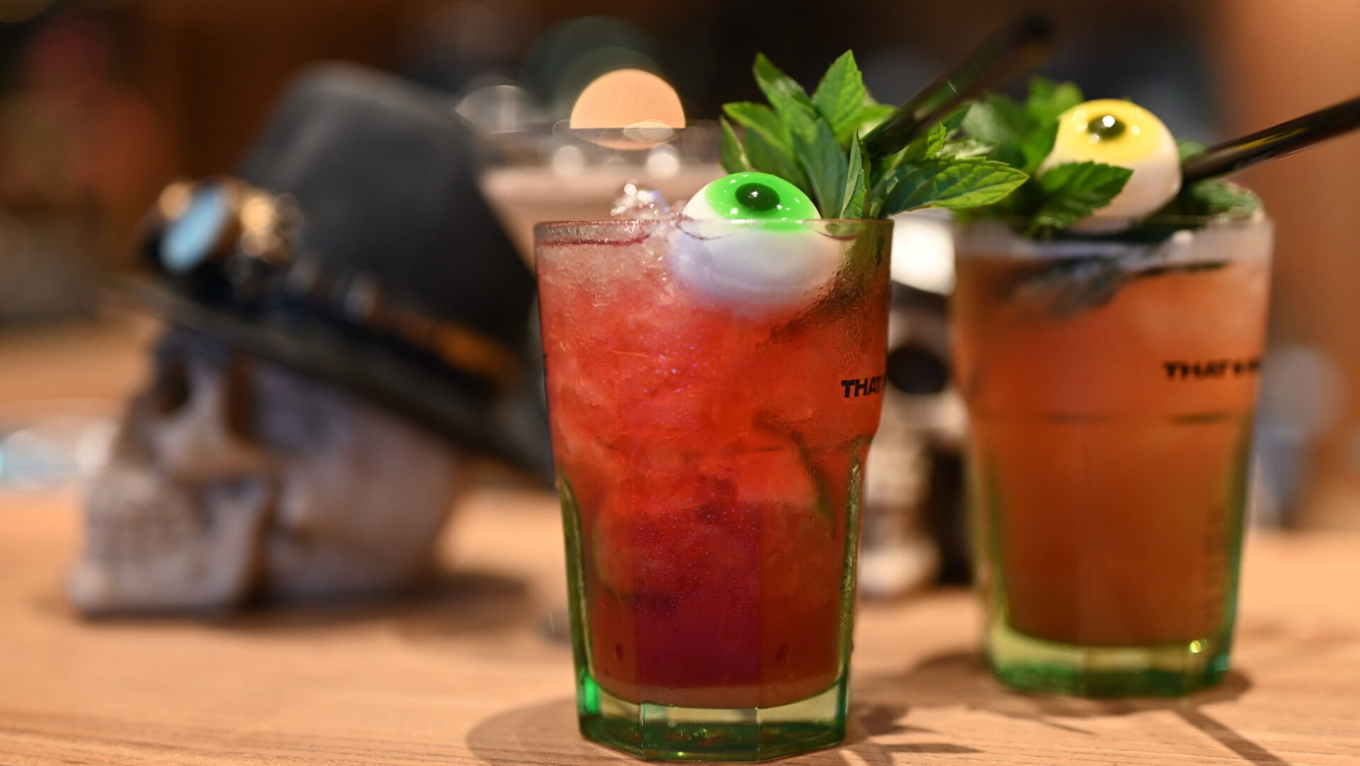 Halloween-Cocktails mit Deko-Schädel und Augenmotiv