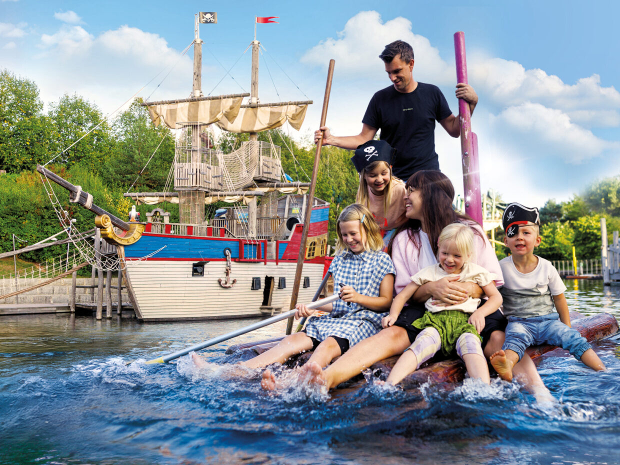 Familie genießt Piraten-Abenteuer im Freizeitpark auf Floß.