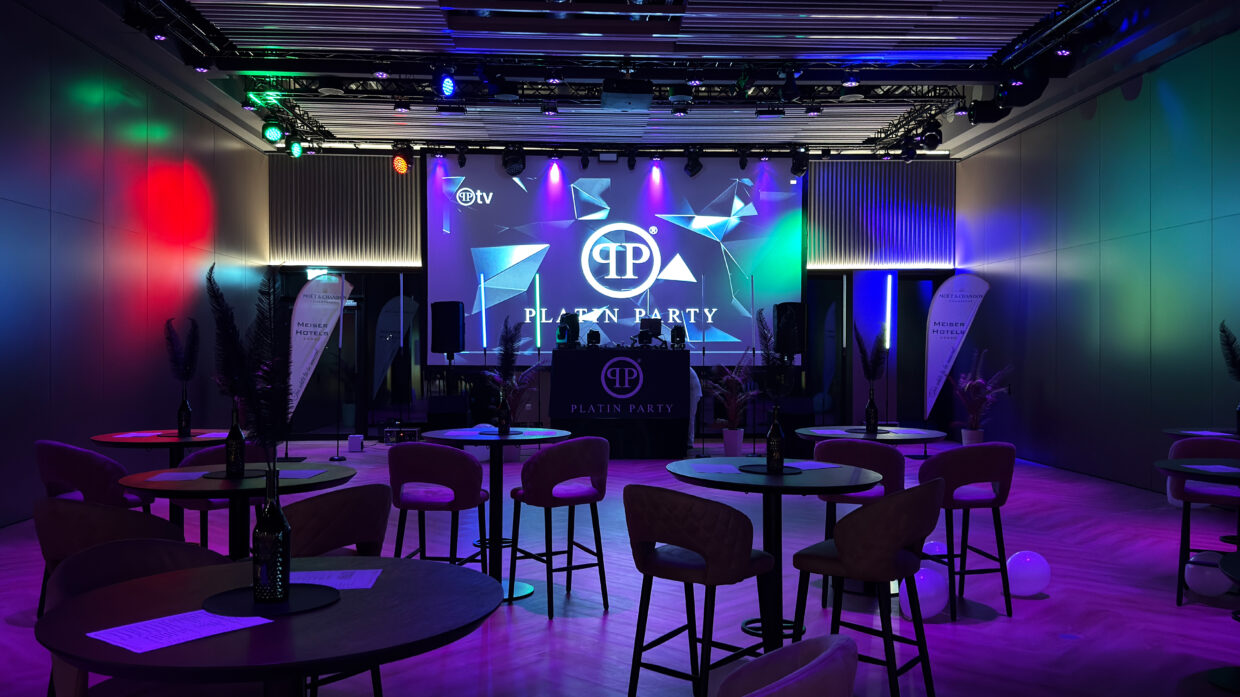 Stylish party venue with colorful lighting and tables.