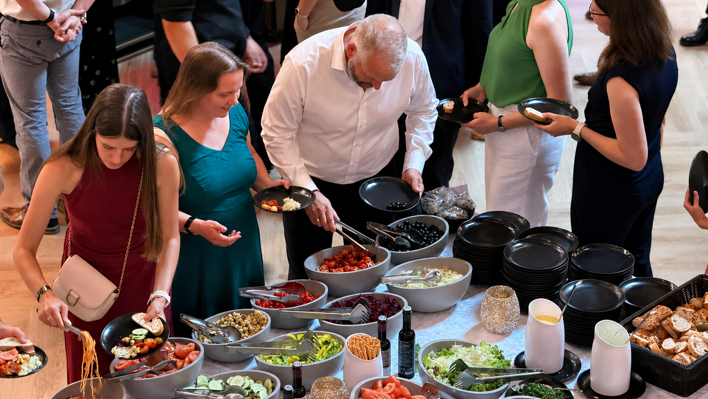 Menschen bedienen sich am Salatbuffet.