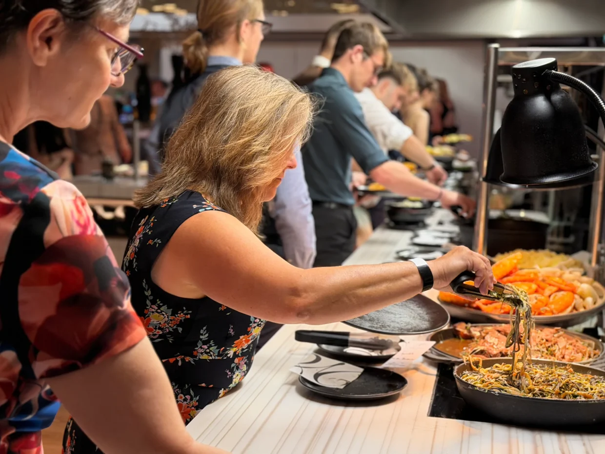 Menschen bedienen sich am Buffet.
