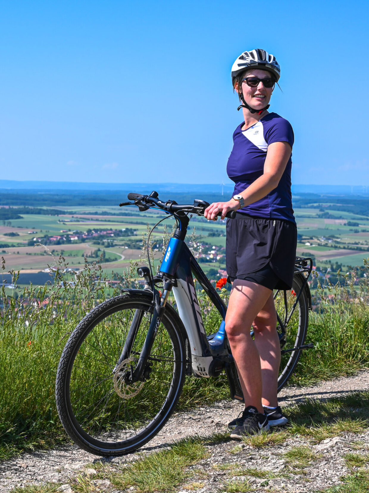 Person mit Fahrrad auf Hügel