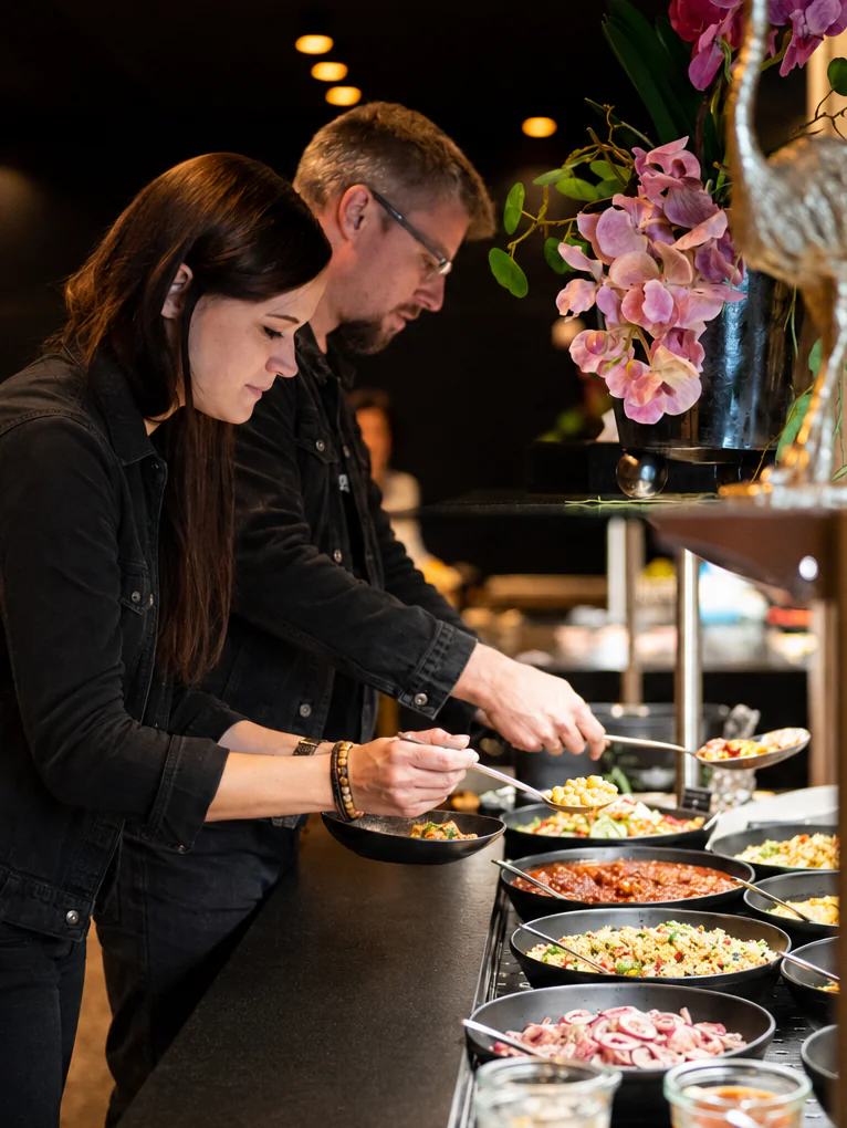 Personen wählen Speisen vom Buffet