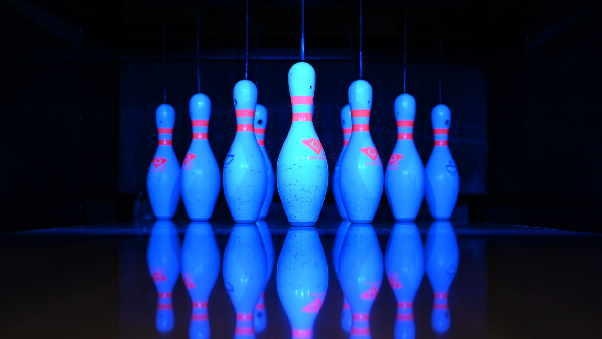 Leuchtende Bowlingkegel unter Schwarzlicht