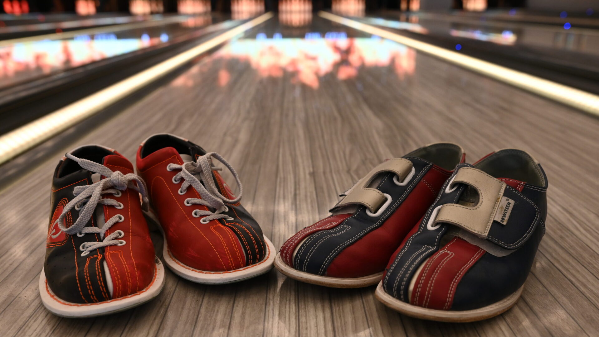 Reihe rot-blauer Sneaker auf beleuchtetem Regal