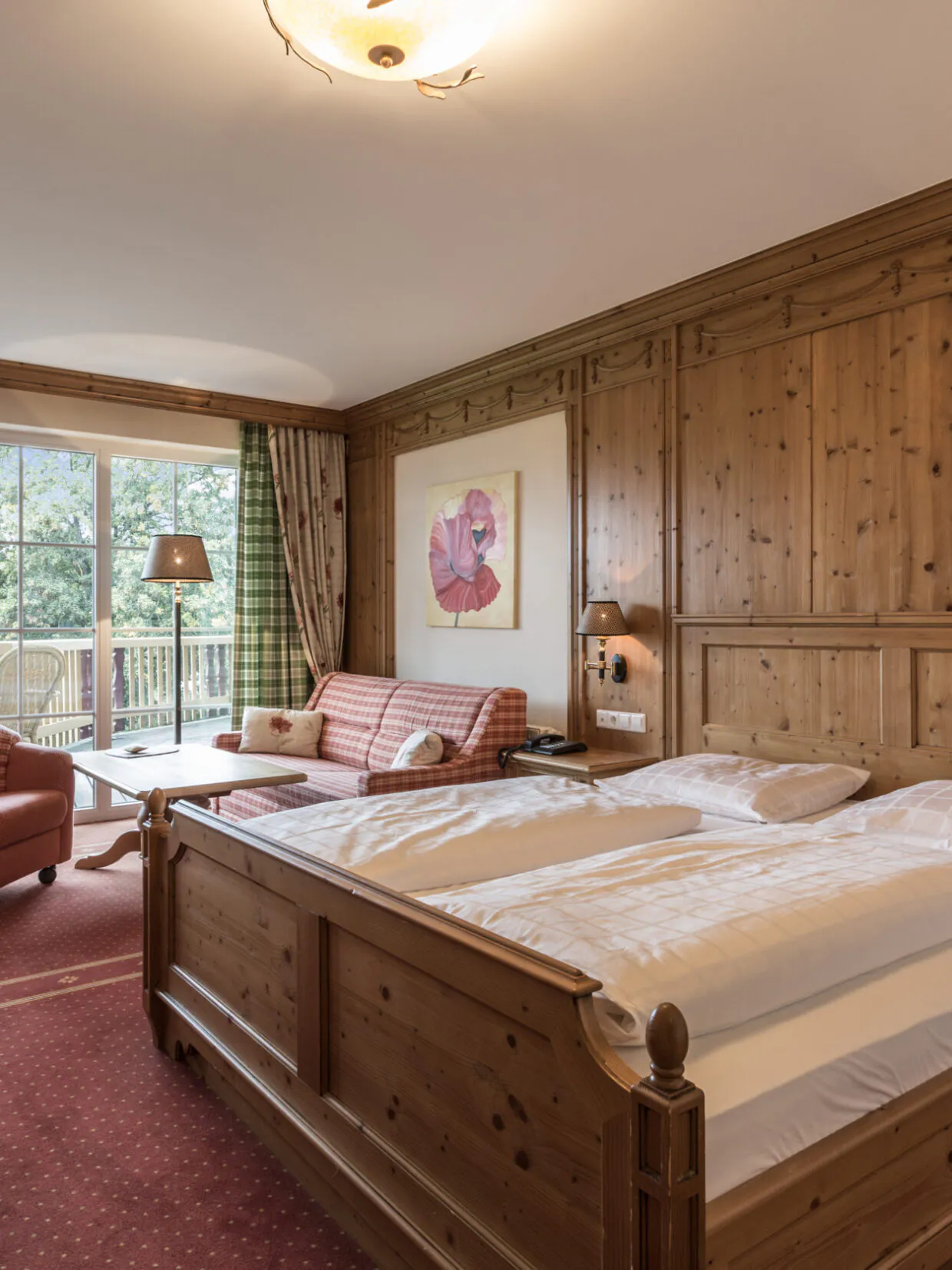 Gemütliches Hotelzimmer mit Holzmöbeln und Balkon.