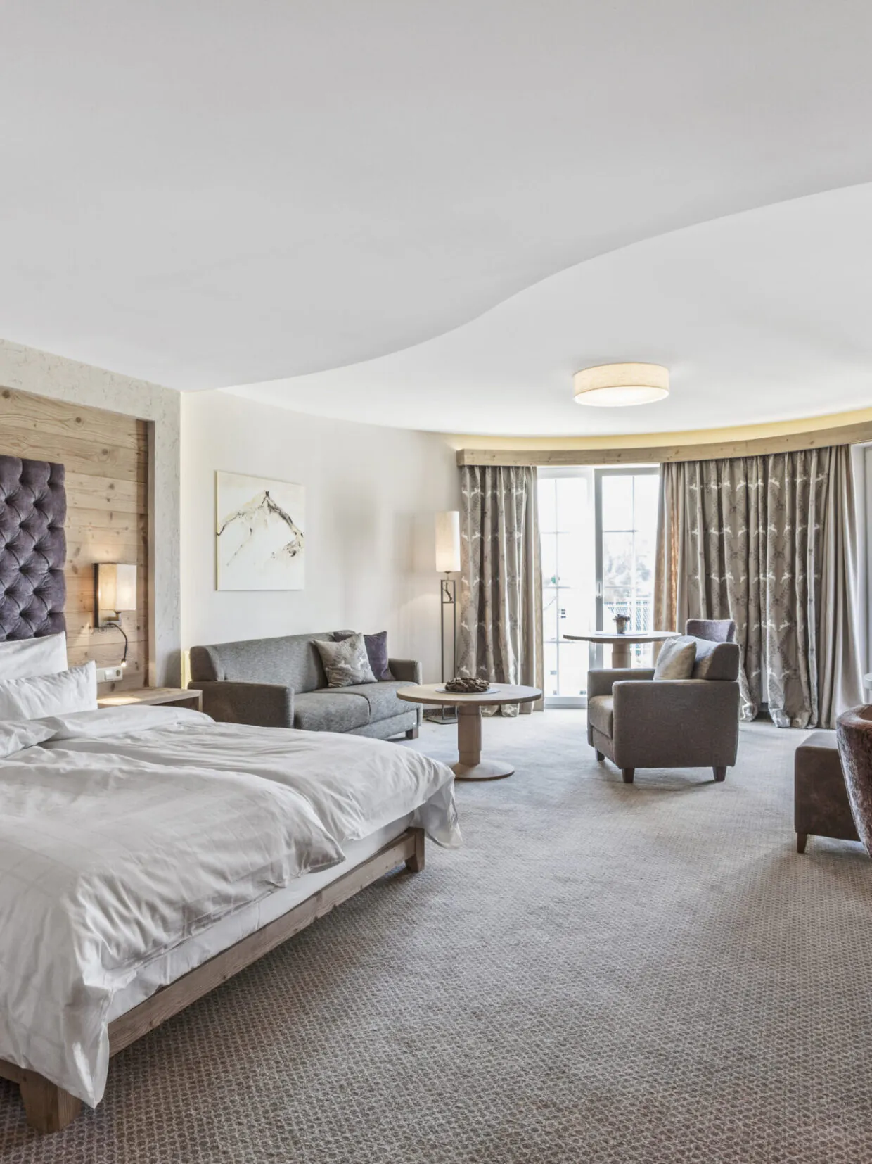 Geräumiges Hotelzimmer mit Doppelbett und Sitzbereich.