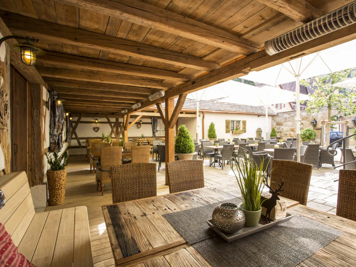Gemütliche Terrasse mit Holzmöbeln im Freien.