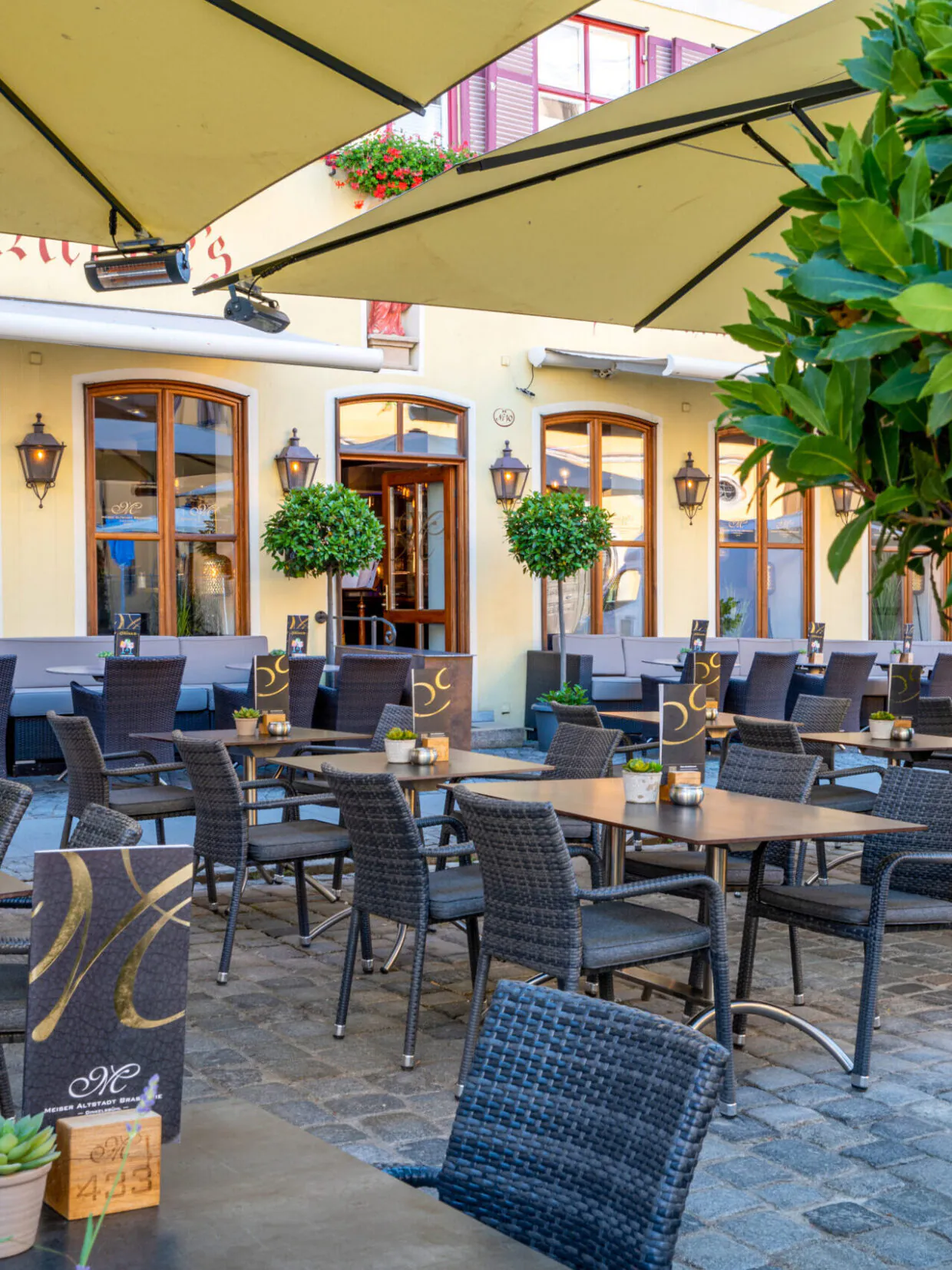 Gemütliche Außenterrasse eines Cafés mit Sonnenschirmen.