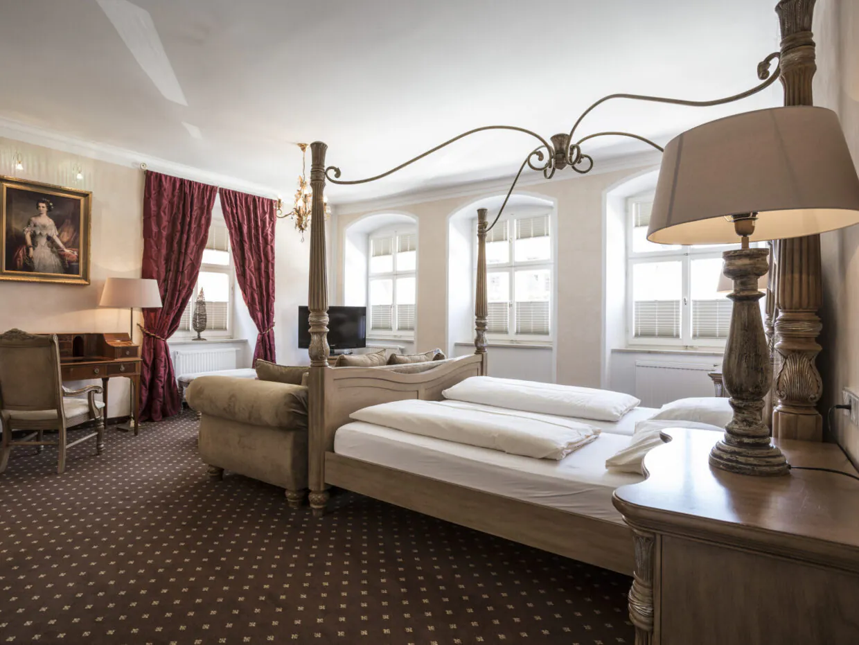 Elegantes Hotelzimmer mit Himmelbett und klassischem Dekor.