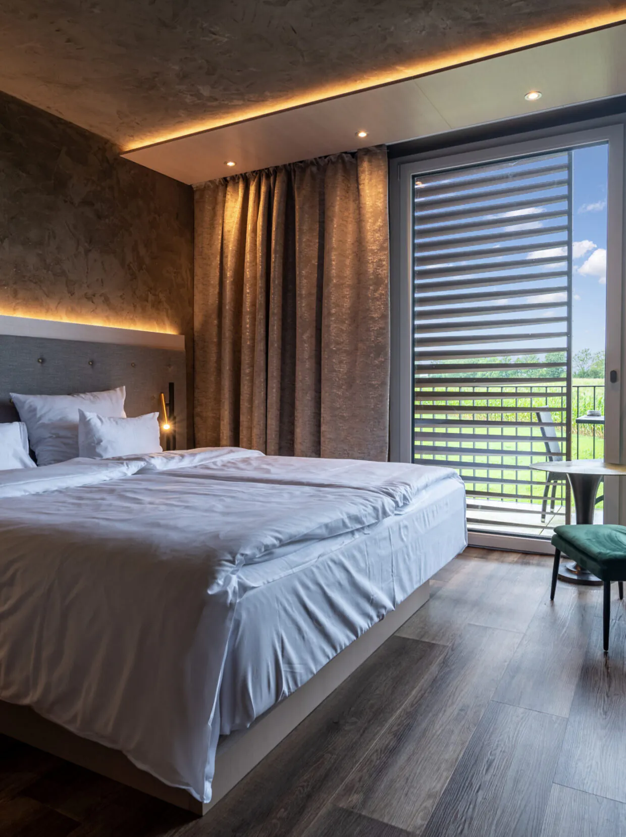 Modernes Hotelzimmer mit Balkon und Gartenblick