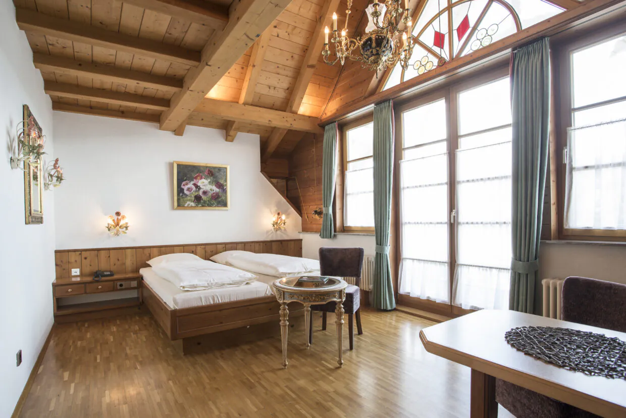 Gemütliches Schlafzimmer im alpinen Stil mit Holzbalkendecke.