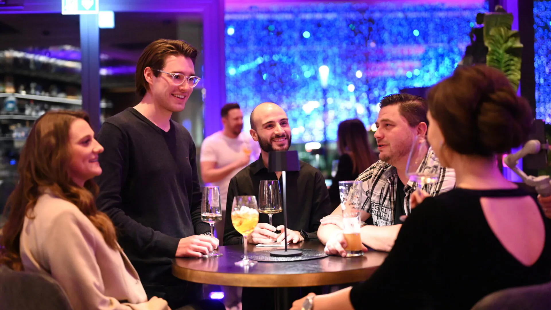 Gruppe von Freunden trinkt in einer Bar gemütlich.