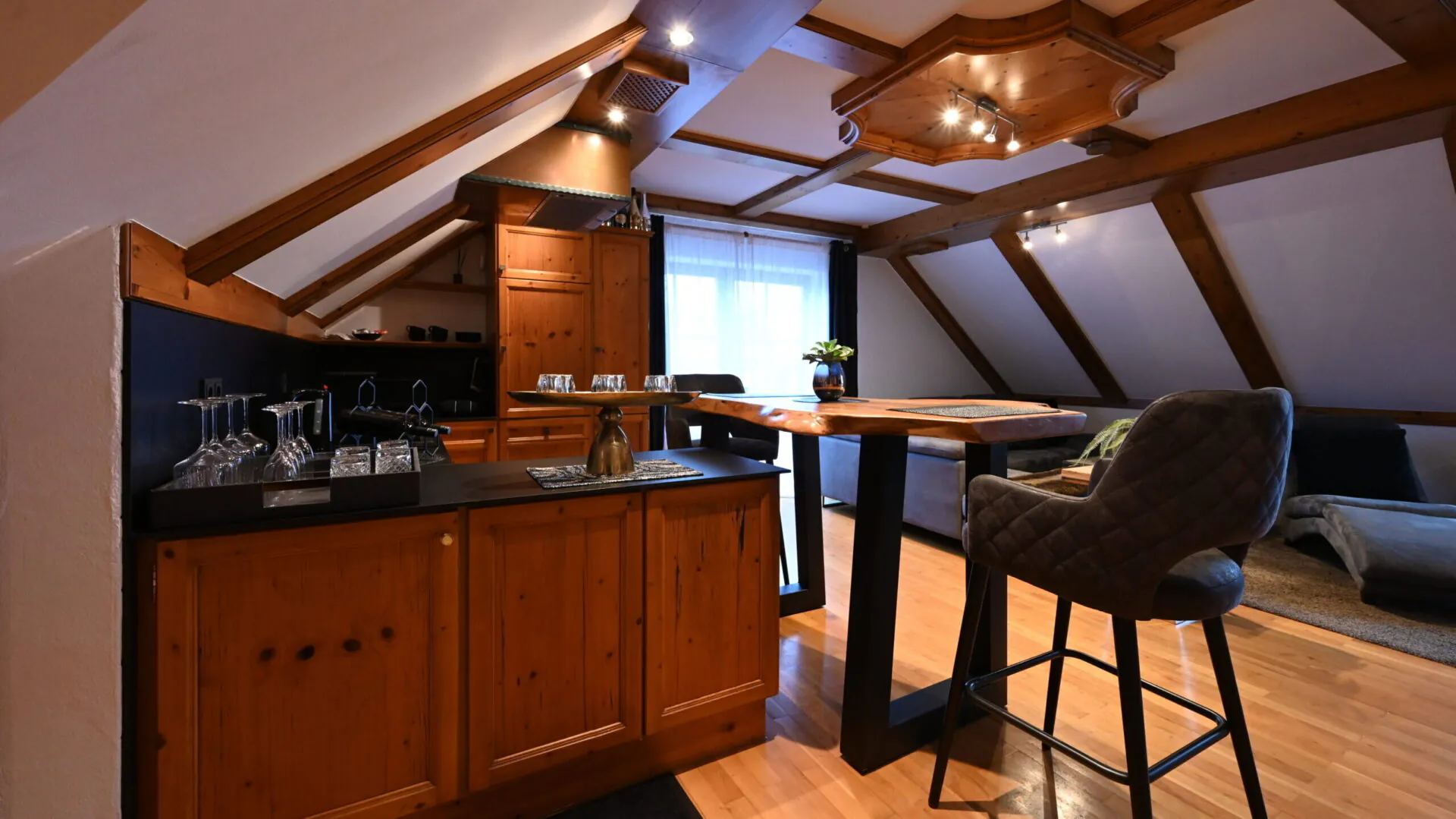 Modernes Dachgeschoss mit Holzküche und Esstisch.