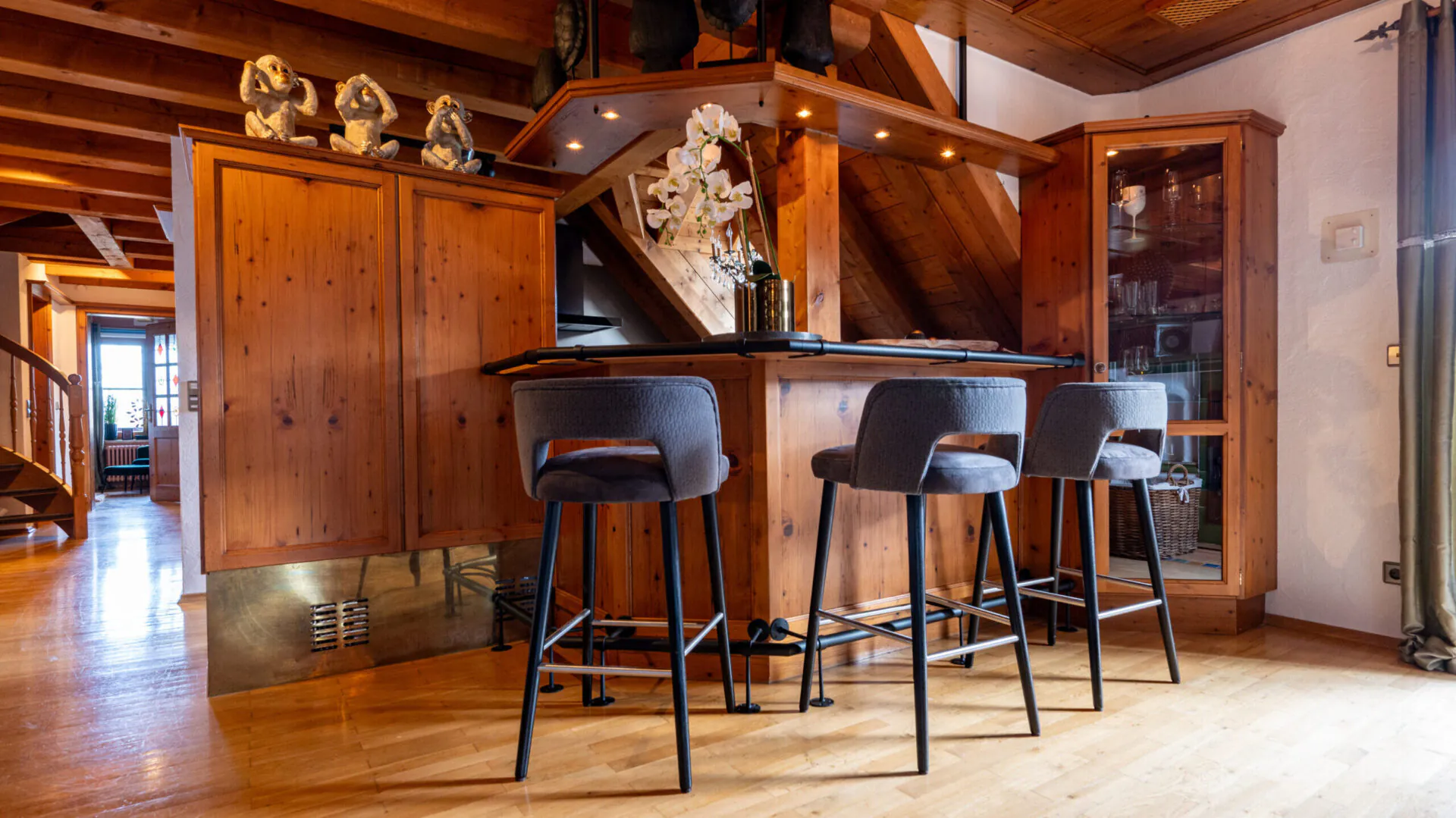 Rustikale Holzküche mit Barhockern und Dekorationen.