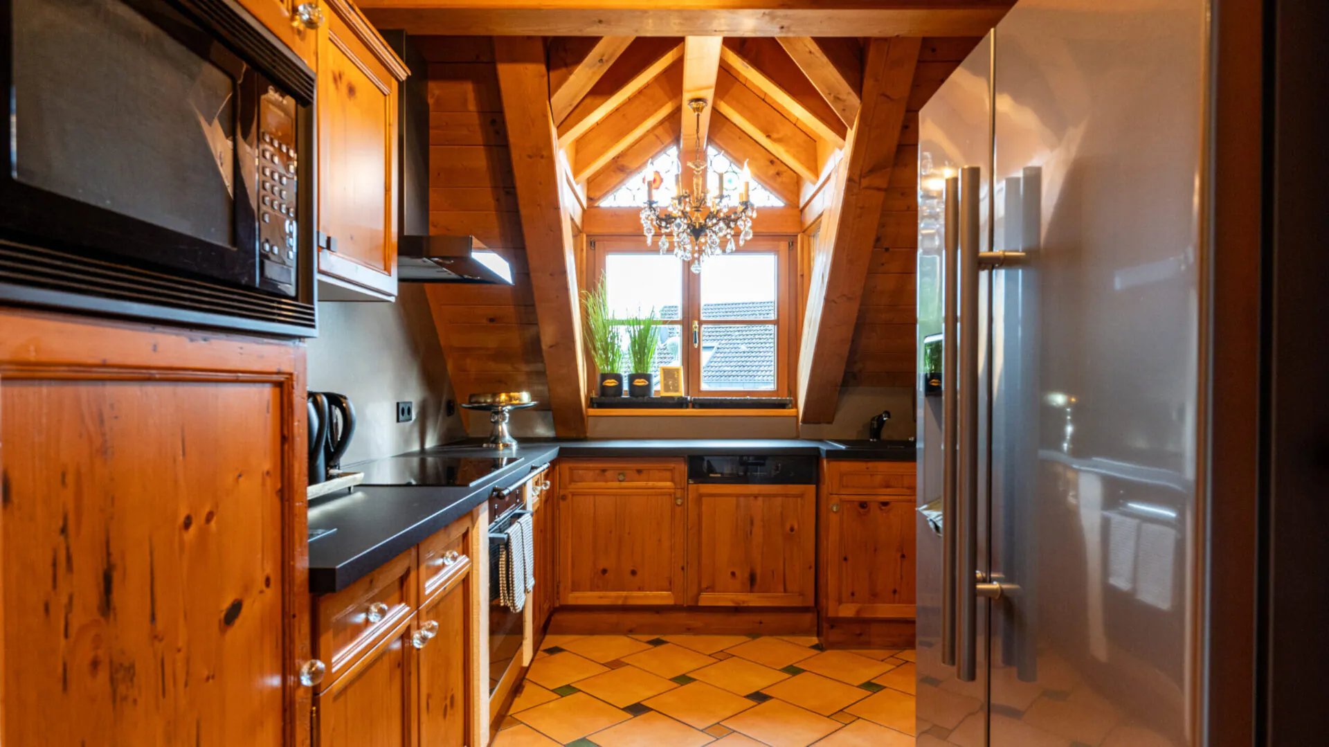 Gemütliche Holz-Küche mit Dachfenster und Kaminofen.