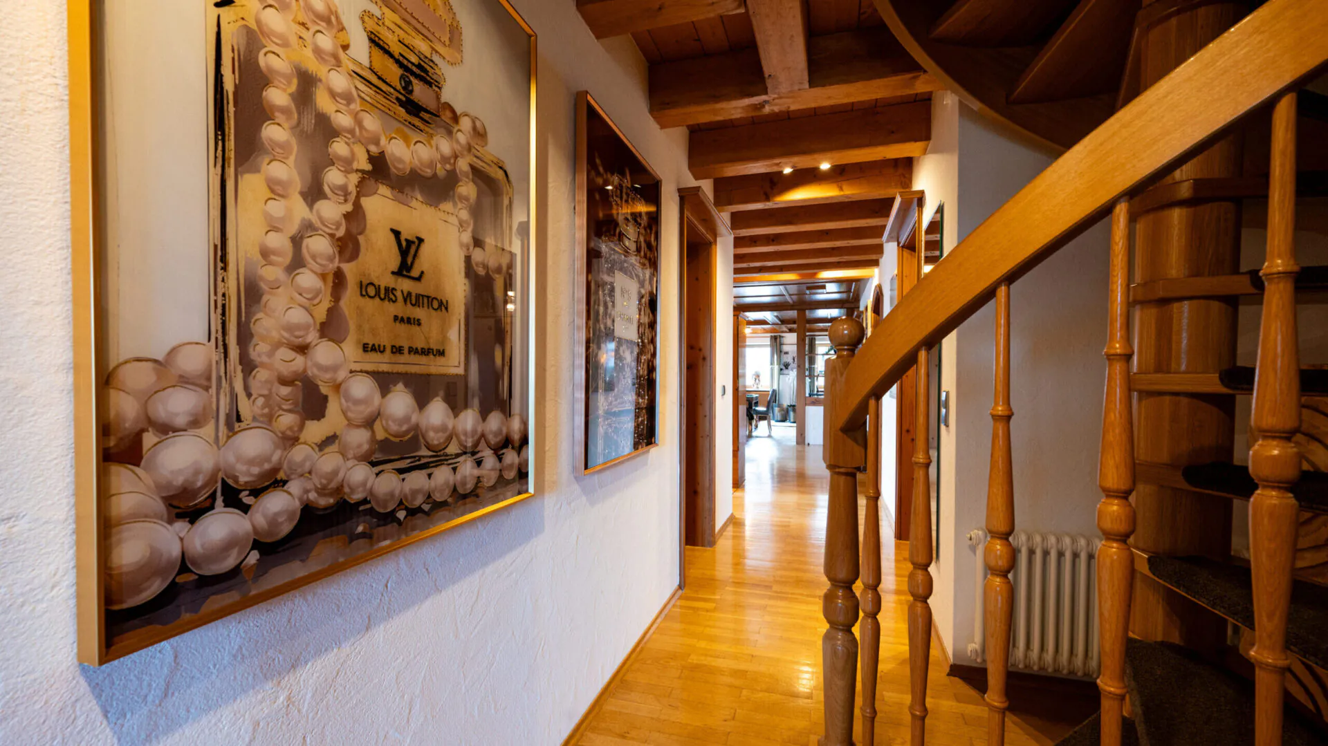 Holztreppe in Flur mit Parfümbild an der Wand