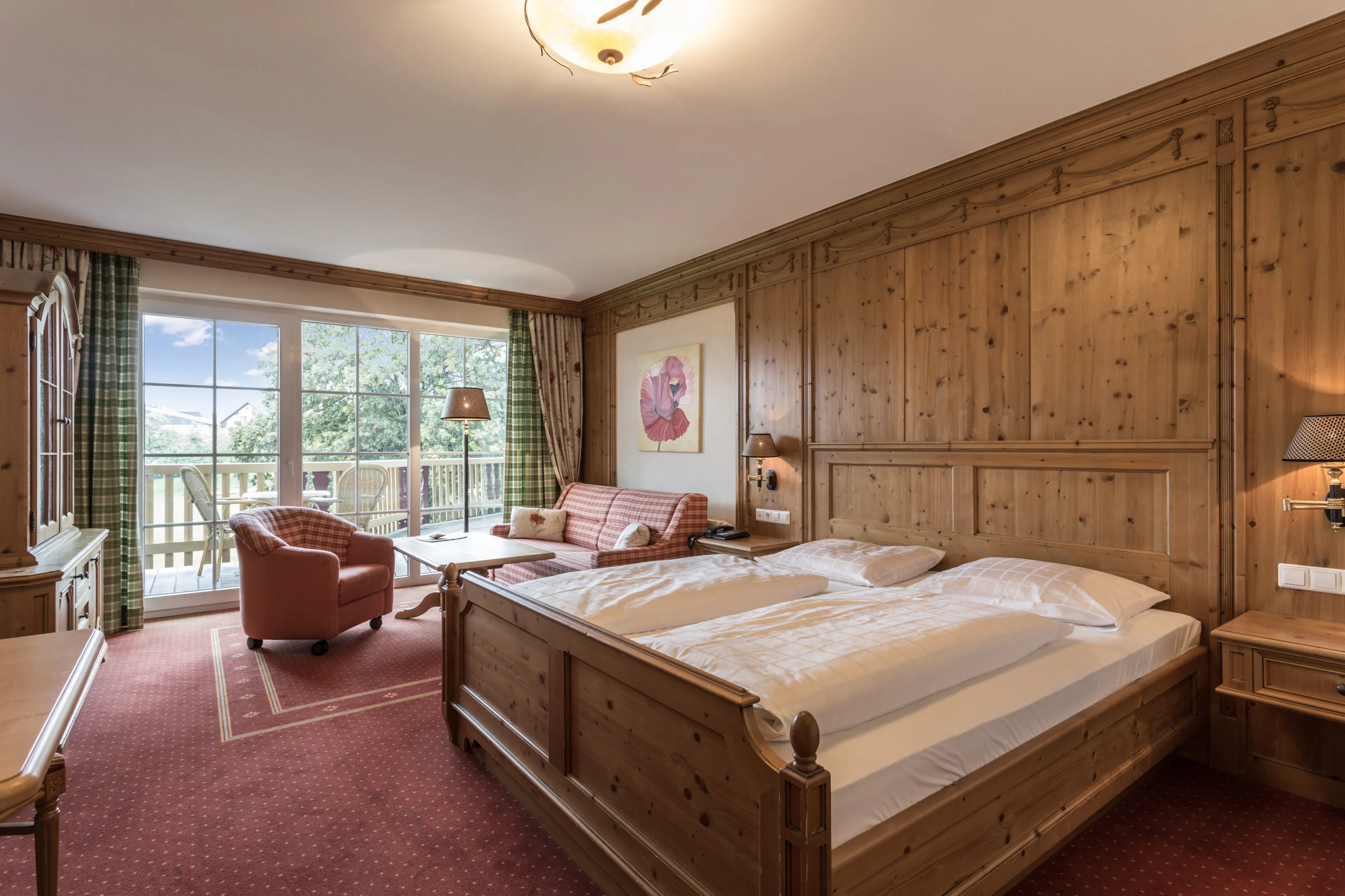 Gemütliches Hotelzimmer mit Holzinterieur und Balkonblick.