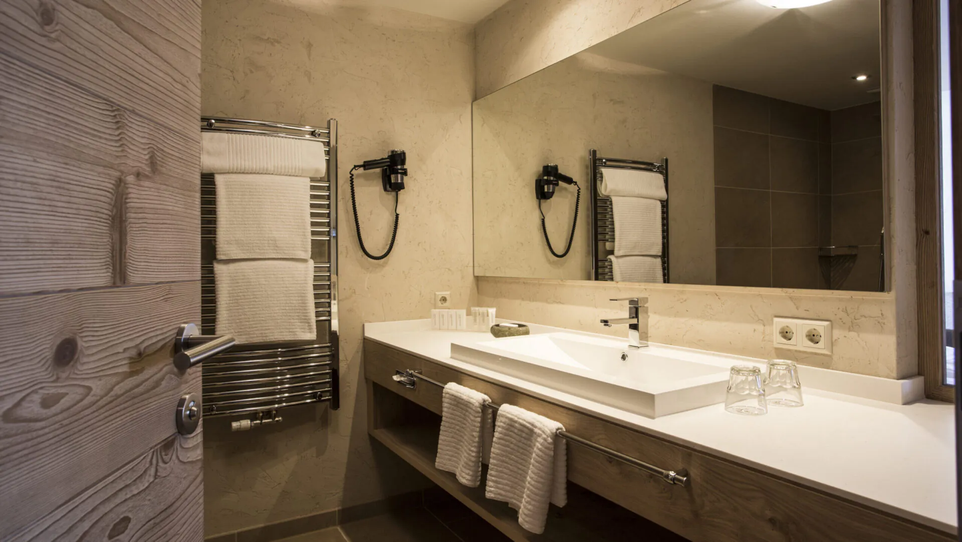 Modernes Badezimmer mit Waschbecken, Spiegel und Handtuchhalter.