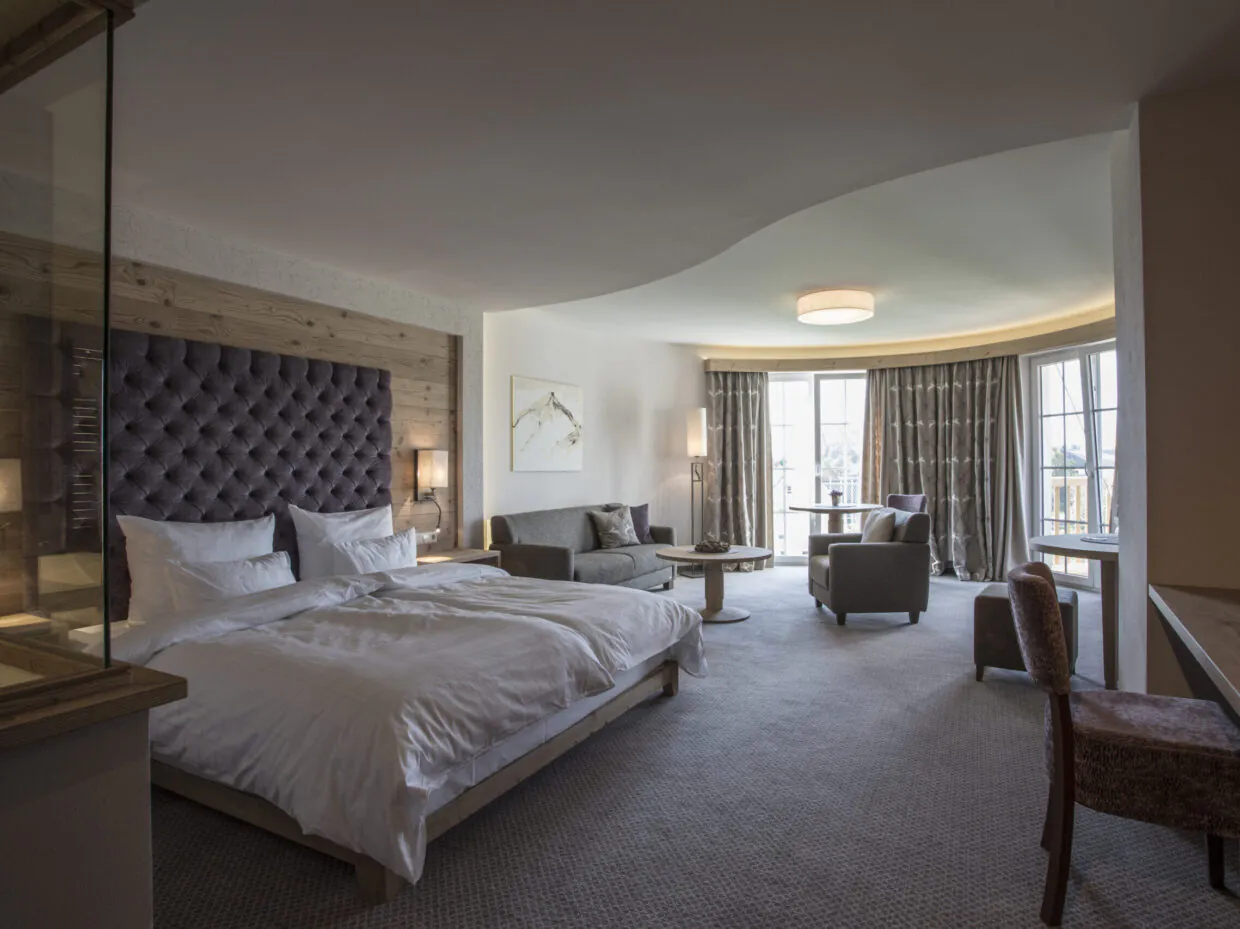 Modernes Hotelzimmer mit Doppelbett und Sitzecke.