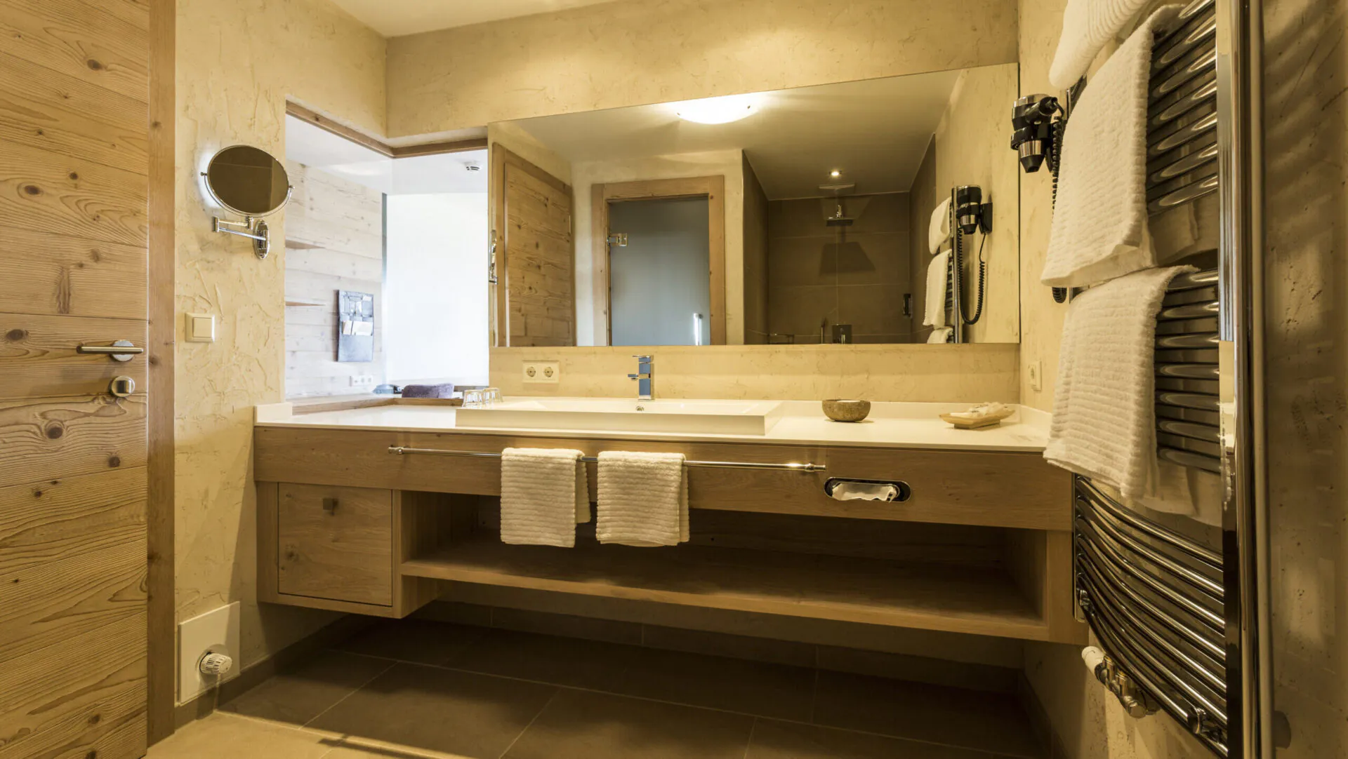 Modernes Badezimmer mit Holzdetails und großem Spiegel.