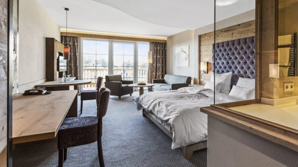 Modernes Hotelzimmer mit Balkon und Bergblick.