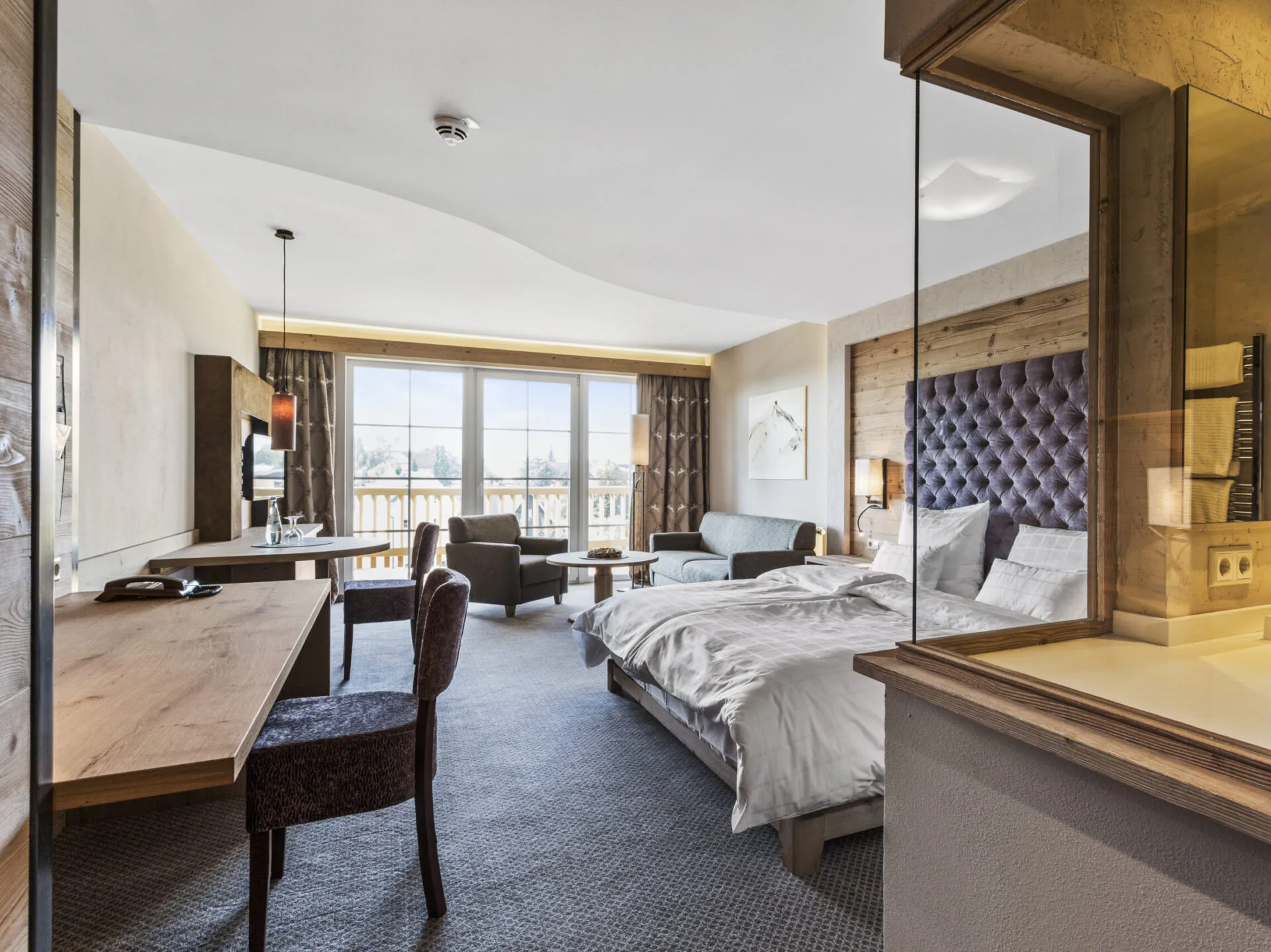 Modernes Hotelzimmer mit Bett, Sofa und Schreibtisch