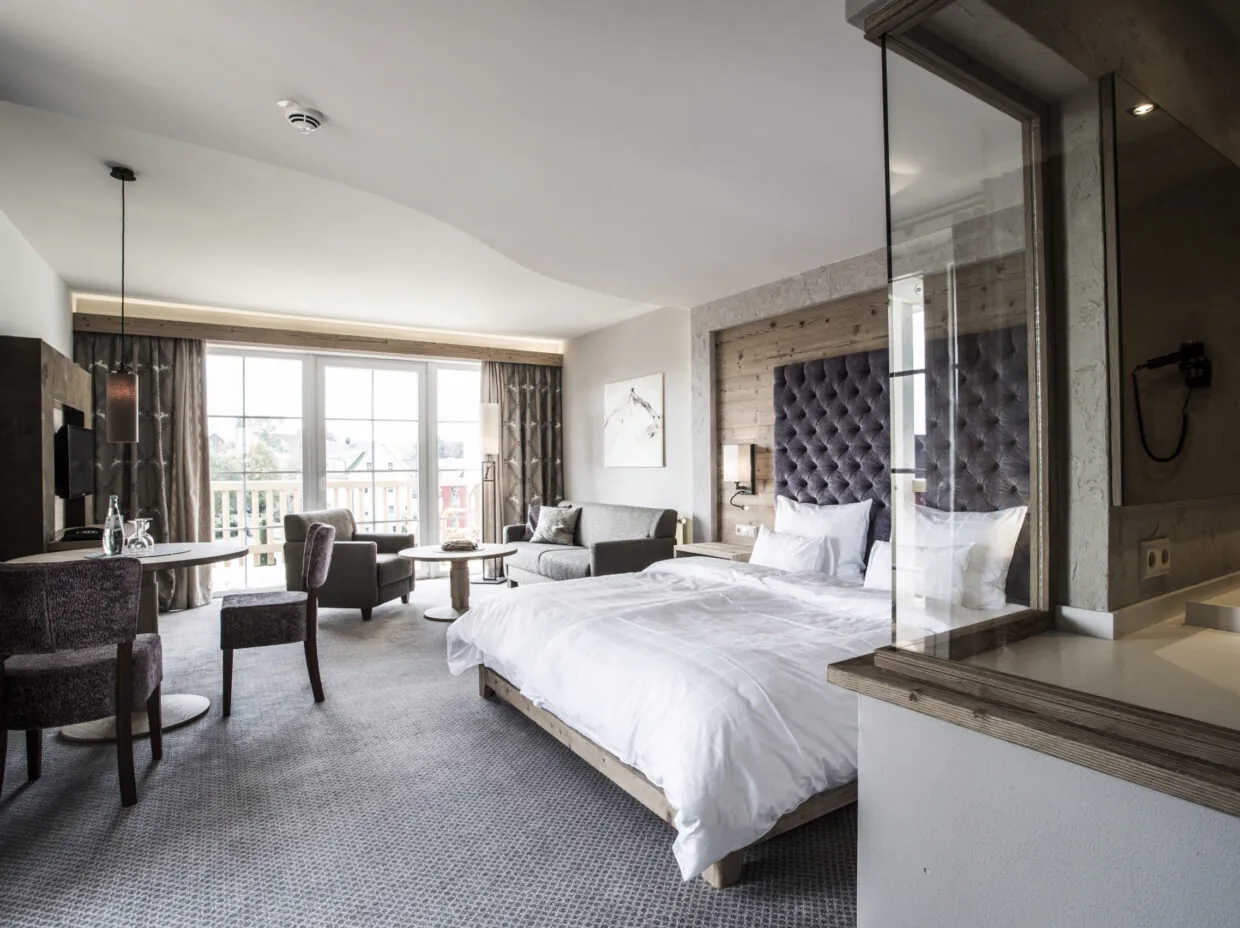 Junior Suite Superior Plus mit zwei Balkonen für bis zu 5 Personen mit Doppelbett, Sitzecke und Balkonblick Richtung Süden