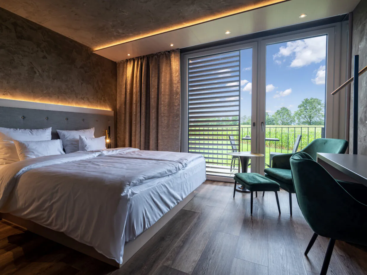 Modernes Hotelzimmer mit Blick auf grüne Landschaft.