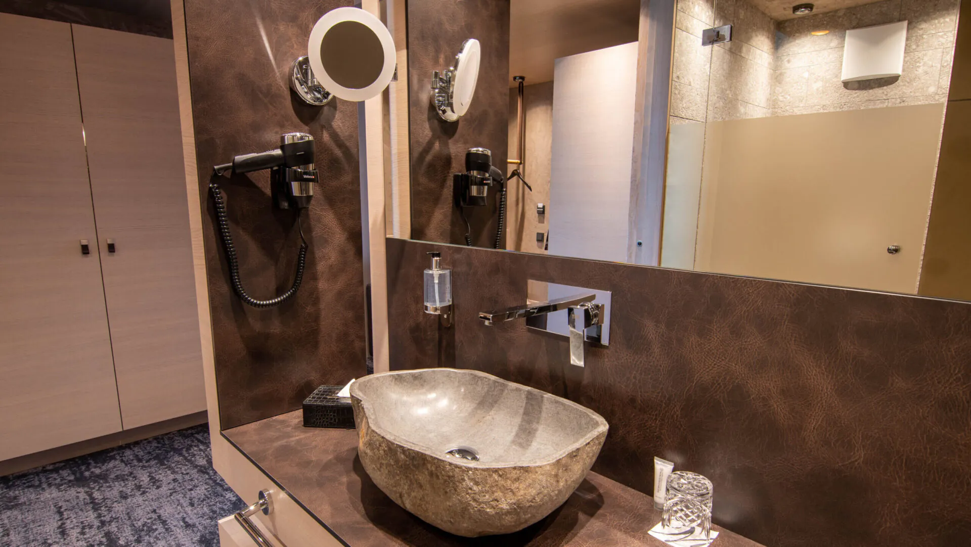 Modernes Badezimmer mit Steinwaschbecken und Spiegel