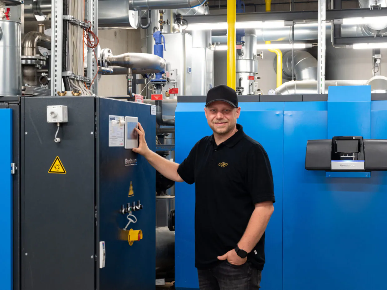 Mann bedient Industrieanlage in technischer Umgebung.