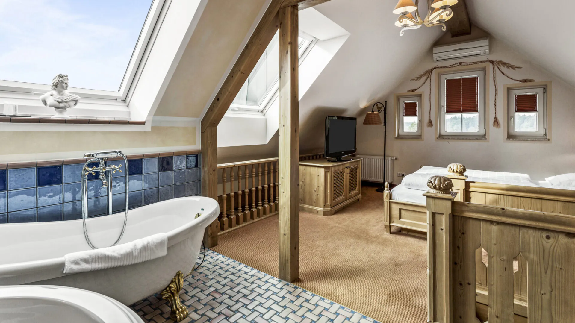 Gemütliches Dachgeschosszimmer mit Badewanne und Holzdekor