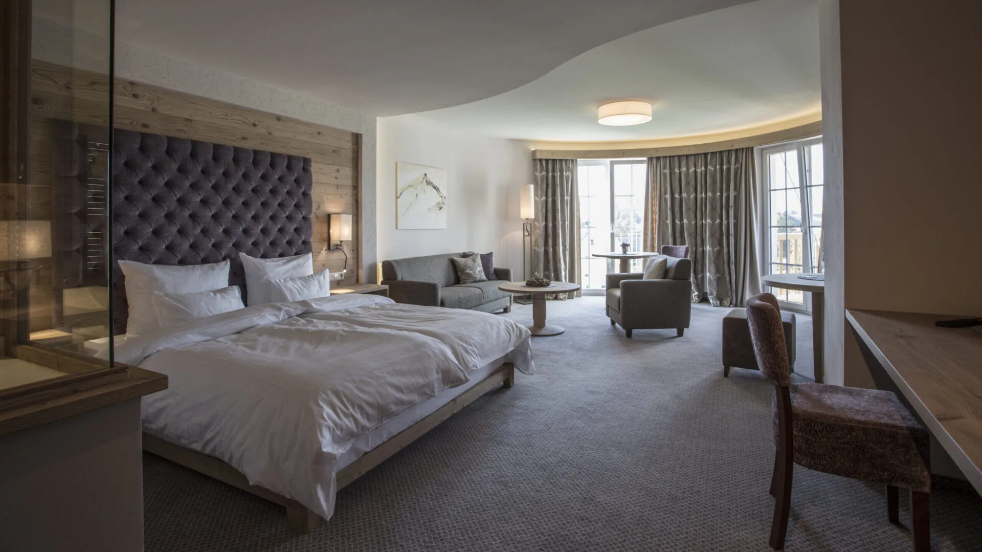 Geräumiges Hotelzimmer mit Bett, Sofa und Fensterblick.